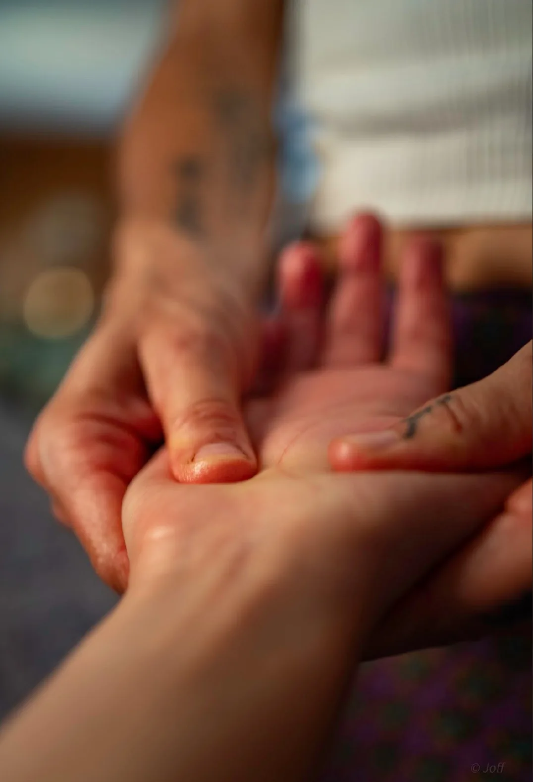 Close-up of Melissa’s thumbs working the palm of a client’s hand